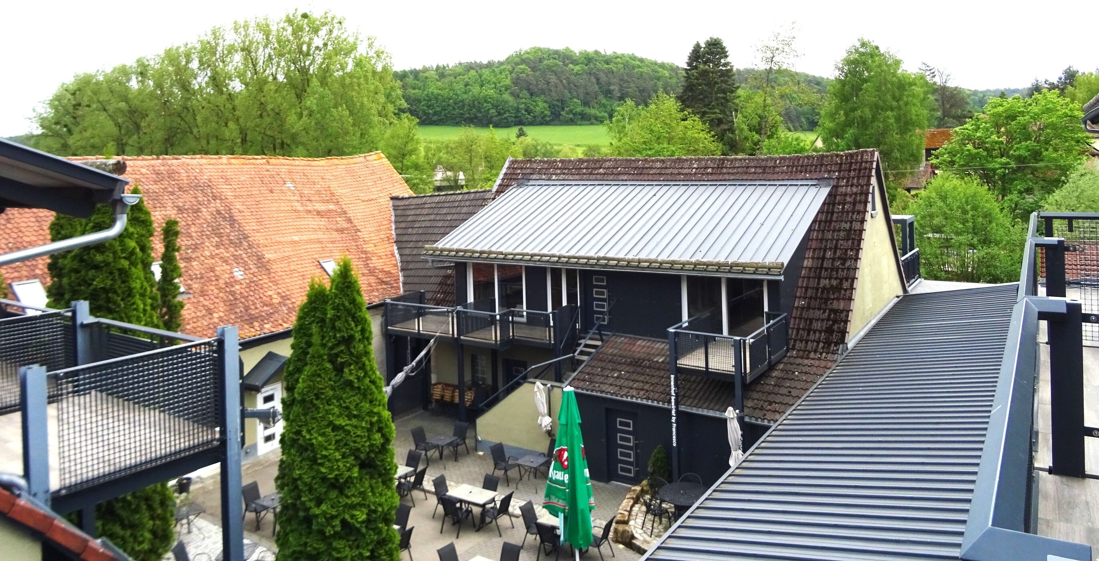 Un bâtiment doté d’un toit en métal, d’un balcon et d’un espace extérieur aménagé pour s’asseoir.