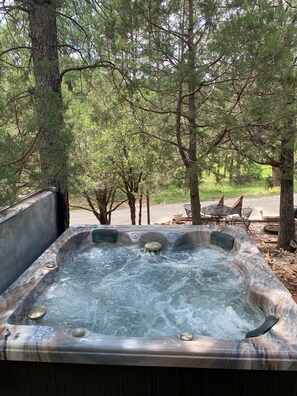 A hot tub surrounded by trees in a natural setting.