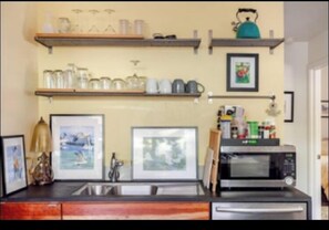 A kitchen with wooden shelves, a microwave, and a sink. - 3/2 Mod Hideaway, Laid-back Loft. ACL/ S Congress/ Downtown. Dog-Friendly (Austin)