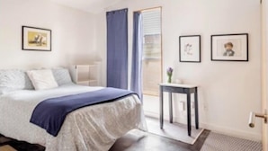 Una camera da letto moderna con un letto, un tavolino e quadri appesi al muro.