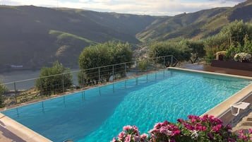 Una piscina con vistas a un valle y colinas.