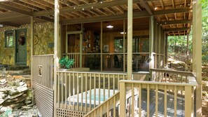 A rustic cabin with a stone exterior, wooden deck, and a covered porch area. - 'Make Your Mark' Cozy Sapphire Cabin with Hot Tub (Sapphire)