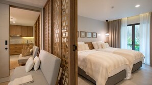 A modern bedroom with a large bed, a sofa, and a view of the outdoors. - EXECUTIVE SUITE (จ.เชียงใหม่)