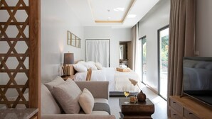 Une chambre d’hôtel moderne équipée d’un lit, d’un canapé, d’une télévision et d’une grande fenêtre.