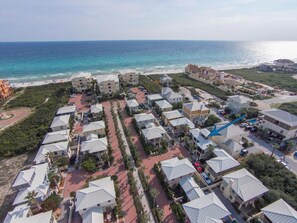 Un quartier résidentiel situé sur la côte, avec de nombreuses maisons à deux étages, une plage et une vue dégagée sur l’océan.