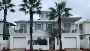 A two-story house with a white exterior, a balcony on the second floor, and a brick driveway. - On 30A, 4 Houses from Beach with Beachfront Pool, between Rosemary and Alys (Seacrest Beach)