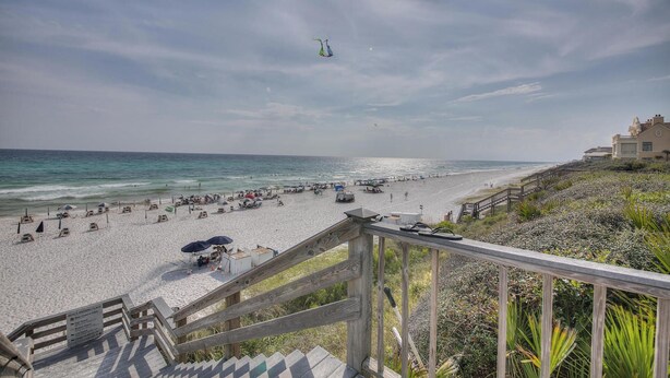 A beach with a wooden staircase leading down to the shore, a clear sky, and a distant view of the ocean. - On 30A, 4 Houses from Beach with Beachfront Pool, between Rosemary and Alys (Seacrest Beach)