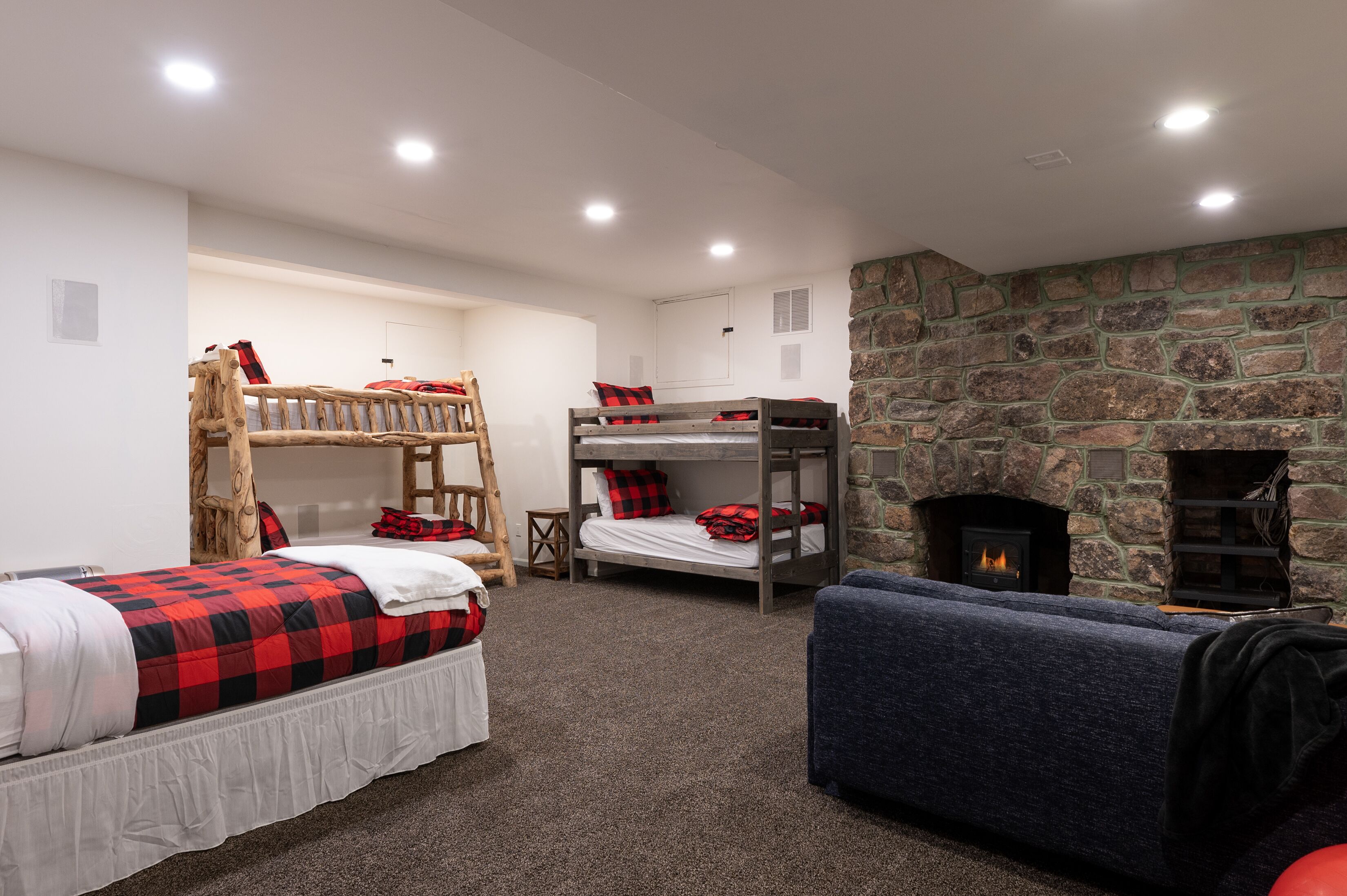 A room with bunk beds, a fireplace, and a couch.