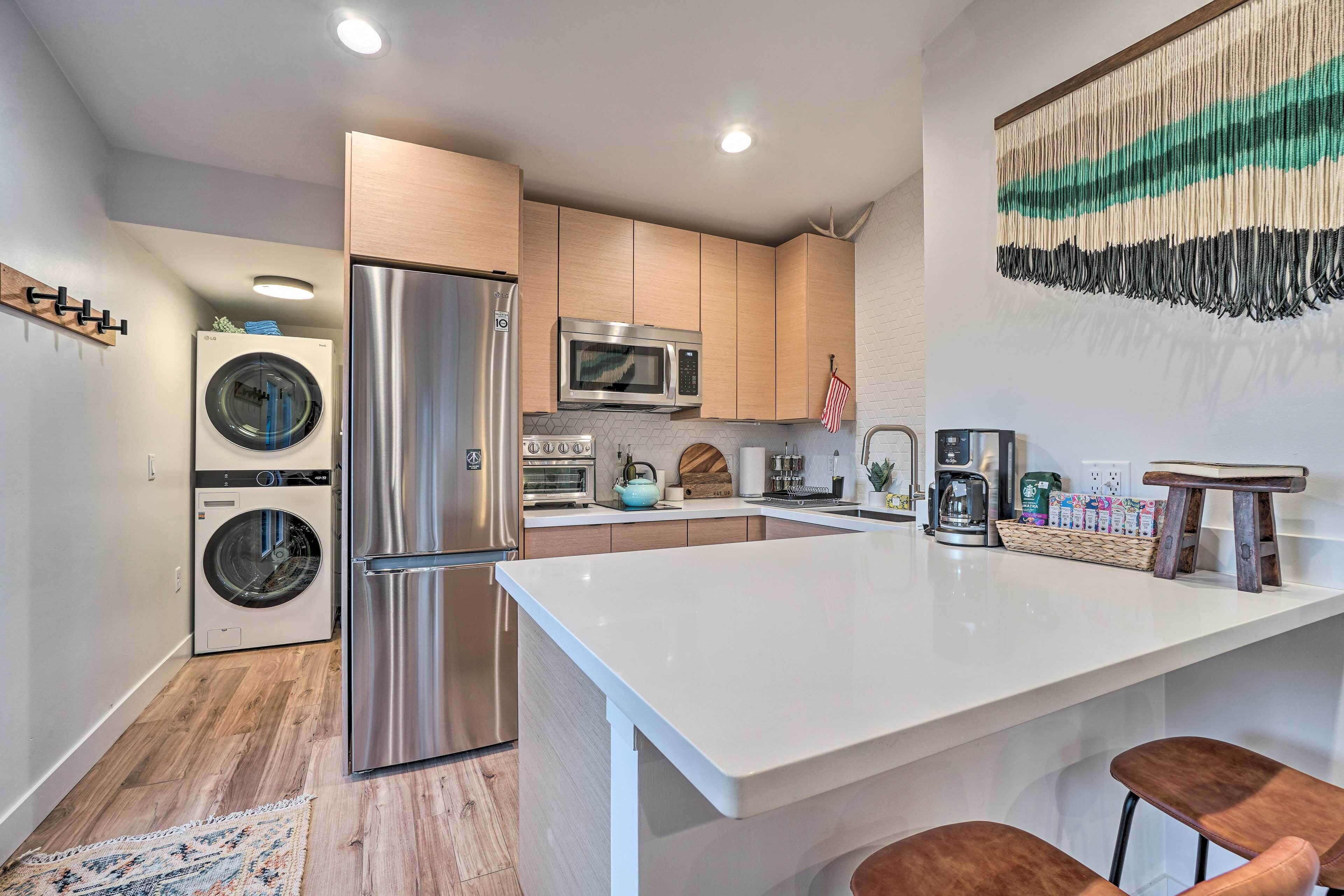 A modern kitchen with stainless steel appliances, a central island, and a hanging American flag.