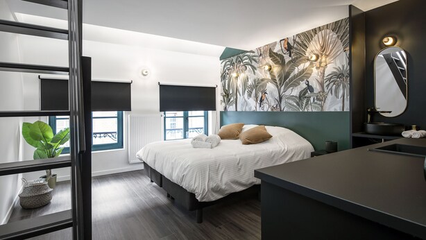 Un dormitorio moderno con una cama grande, una mesita de noche, un espejo y un mural en la pared.