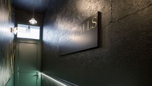 Un pasillo con una puerta verde, un cartel que dice "SECRET WALLS" y una pared con textura.