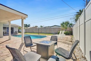 A covered patio area with a pool, outdoor furniture, and a wooden fence. - Stunning 4BR Hted Pool &Jacuzzi Close 2 the Beach (Deerfield Beach)