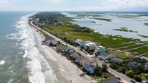 An aerial view of a coastal area with a beach, houses, and a pier. - Luxury Sea Cabin Guest Suite - Across from Beach (Folly Beach)