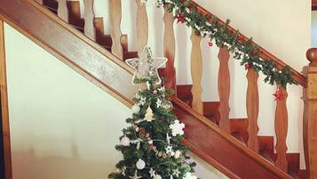 A staircase with a Christmas tree decorated with ornaments and a garland.