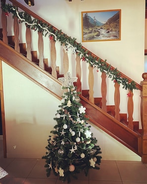 A staircase with a Christmas tree decorated with ornaments and a garland.