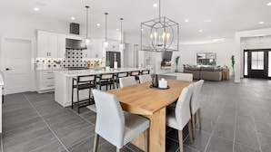 A modern kitchen with white cabinets, a central island, and pendant lighting. - Querencia  | Pool, Hot Tub, Putting Green, Fire Pit, TPC Golf | Scottsdale (Scottsdale)