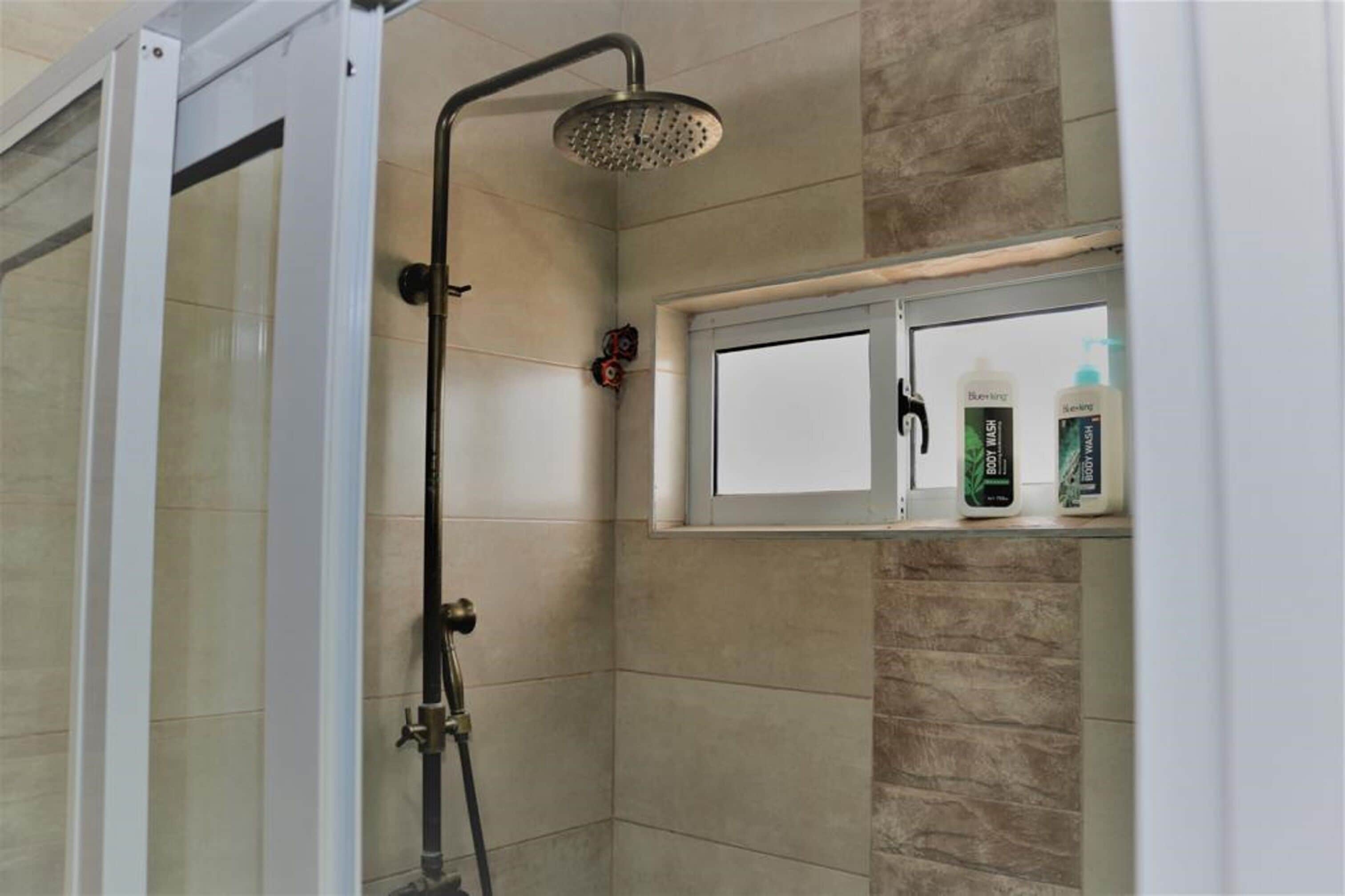 Chambre Deluxe avec lits jumeaux | Salle de bain | Douche, chaussons, serviettes fournies, savon