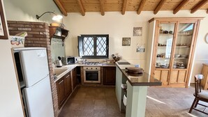 A kitchen with a refrigerator, stove, microwave, and wooden cabinets. - Detached house: relaxation.  CIR 19087053C261141 CIN IT087053C2WIFBFSGJ (Sicilia)