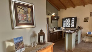 A kitchen with wooden cabinets, a central island, and a hanging lantern. - Detached house: relaxation.  CIR 19087053C261141 CIN IT087053C2WIFBFSGJ (Sicilia)