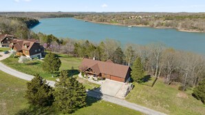 Una casa grande con una amplia terraza y vista al lago.