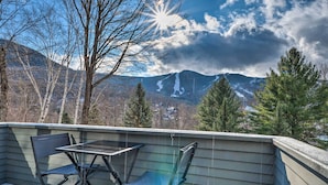 A deck with a table and chairs overlooking a mountainous landscape with snow patches. - Lincoln Escape w/ Deck: 1 Mi to Loon Mountain! (Lincoln)