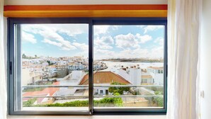 A balcony with a view of a coastal town, featuring terraced buildings and a marina. - Vila Vida (8) | Private Heated Pool | Sea & Beach | Roof Terrace | Restaurants (Ferragudo)