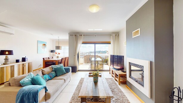 A modern living room with a sofa, coffee table, TV, and dining area. - Vila Vida (8) | Private Heated Pool | Sea & Beach | Roof Terrace | Restaurants (Ferragudo)