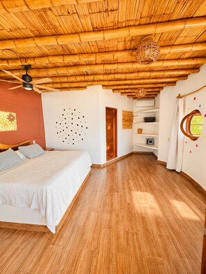 A bedroom with a wooden ceiling, a bed with white bedding, a wall-mounted light fixture, and a window with a curtain. - Breathtaking Sea View Apartment Casa Xochi (San Agustinillo)