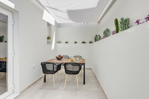 Comedor con mesa de madera, sillas negras y frutero.