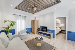 Una sala de estar moderna con sofá, mesa de centro y televisor.