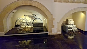 Un intérieur avec des plafonds en forme d’arc, un vélo et des bagages empilés.