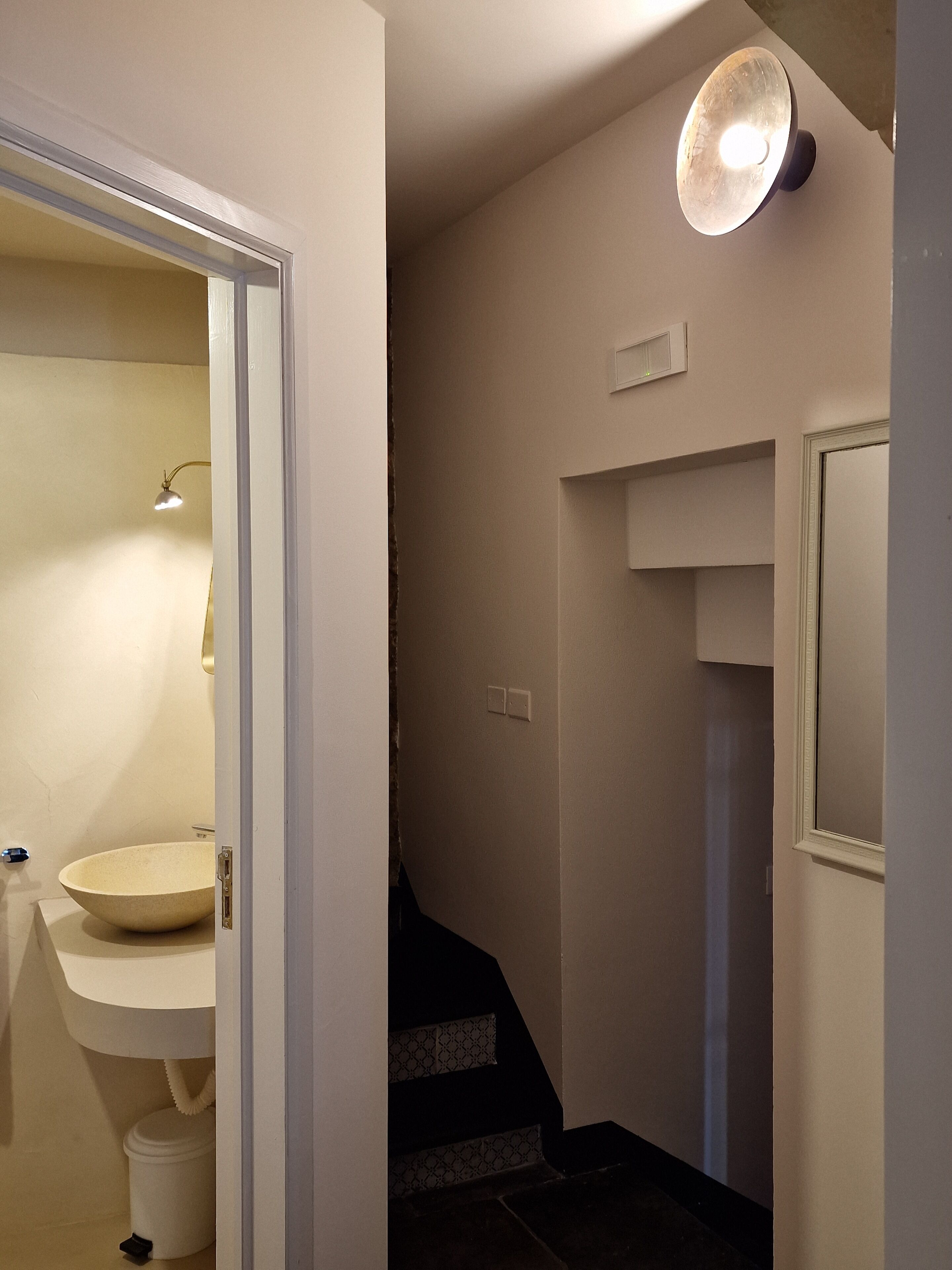 Un bagno con lavandino, specchio e illuminazione.