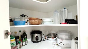 A kitchen with a coffee maker, a blender, and various kitchen utensils.