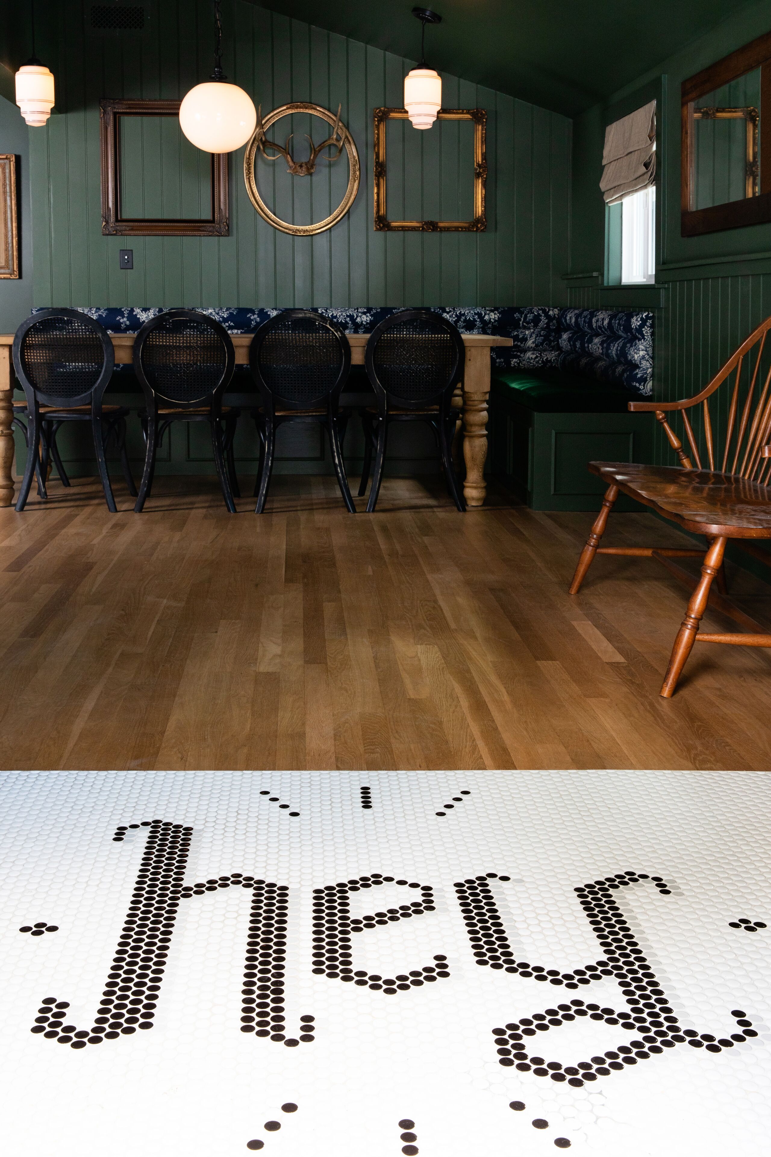 A dining area with wooden flooring, a wooden chair, and a table with four chairs.