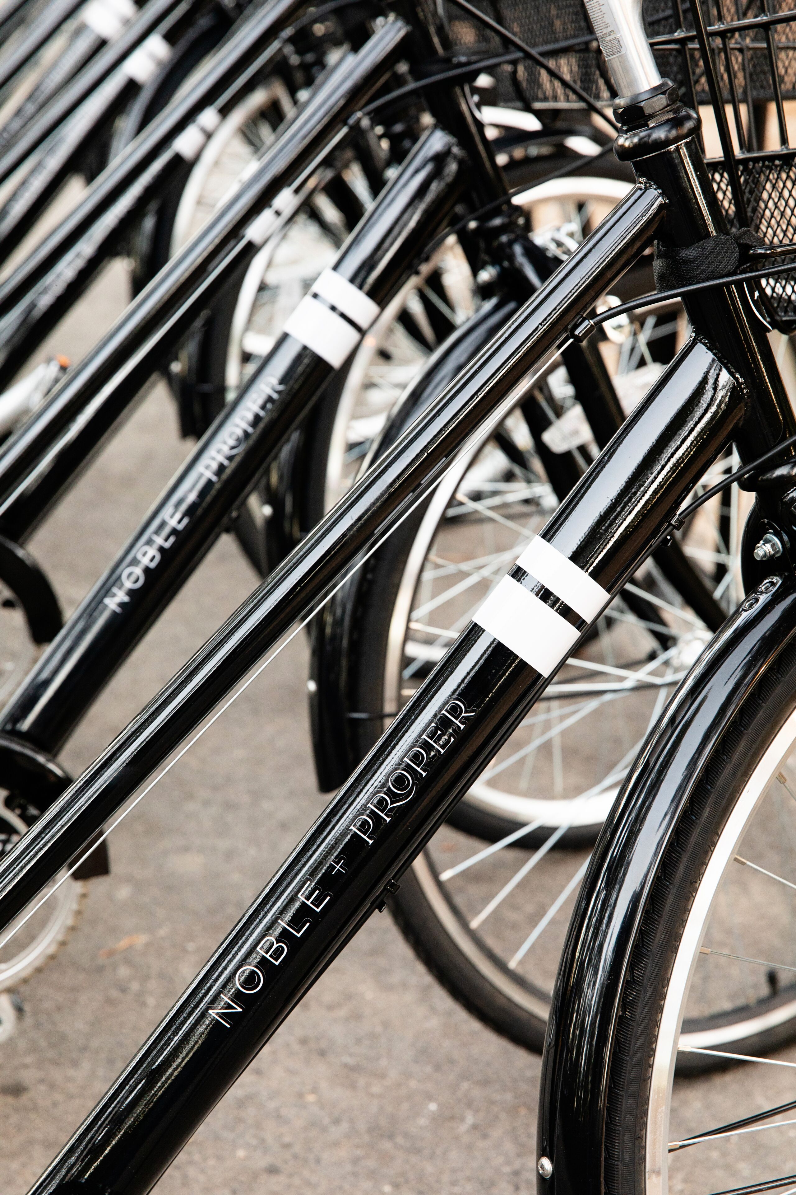 A close-up of a bicycle with the inscription "NOBLE+PROPER" on its frame.
