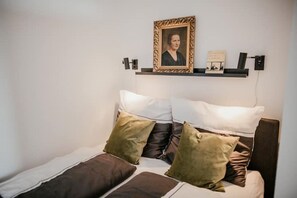 Cozy retreat with a plush bed and framed artwork.