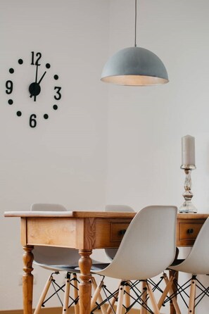 Enjoy meals in this stylish dining area with a classic table, modern chairs, and a pendant light.