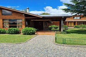 Guests can enjoy a peaceful retreat amidst lush greenery and a covered porch.
