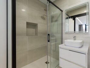A modern bathroom with a glass-enclosed shower, a white sink, and a mirror above it. - Cian Beach Home By CanariasGetaway (Las Palmas de Gran Canaria)