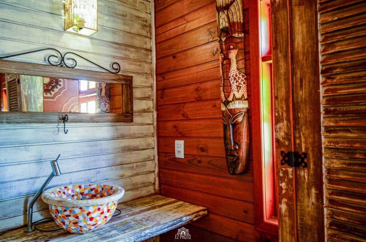 A wooden interior with a wooden sink, a mirror, and a decorative mask on the wall.
