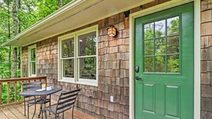 A wooden deck with a table and chairs, a green door, and a window with a light fixture. - Highlands Escape, 1 mile to town - Retreat to the Mountains to Relax (Highlands)