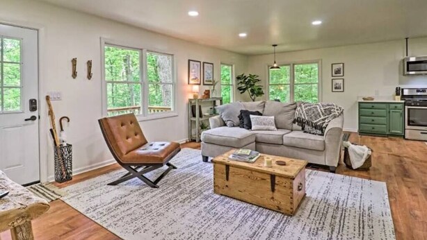 A spacious living room with a large window, a sofa, a coffee table, and a chair. - Highlands Escape, 1 mile to town - Retreat to the Mountains to Relax (Highlands)