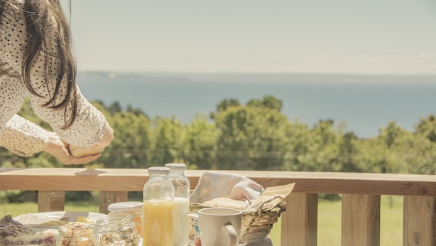 Una mesa de desayuno con comida y bebidas, con vistas a un paisaje pintoresco.
