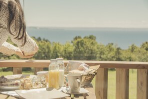 A breakfast table with food and drinks, overlooking a scenic view. - Ave Lodge Frutillar (Frutillar)