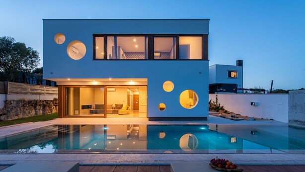 A modern two-story house with a swimming pool, large windows, and circular cutouts on the facade. - Villa Artist with Pool (Pula)