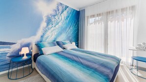 A bedroom with a large bed, a nightstand, a lamp, and a view of the ocean through sheer curtains. - Villa Artist with Pool (Pula)