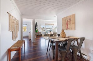 Relax in this open-plan living space with a dining area, featuring a bench, table, and chairs.