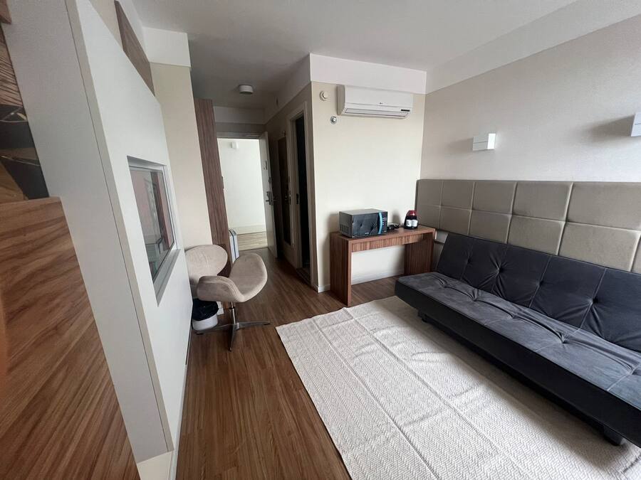 Una sala moderna con un sofá, una mesita de madera y una silla.