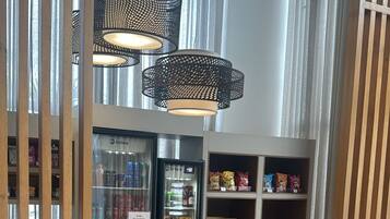 Een modern interieur met een zithoek, een gekoelde vitrine en hangende pendantlampen.