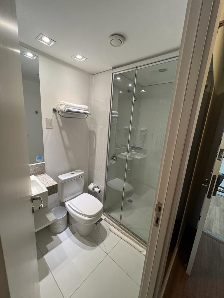 A modern bathroom with a toilet, sink, and glass-enclosed shower.